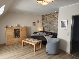 a living room with a couch and a table at Darssblick Barth - Boddenblick, Tiefgarage & Aufzug in Barth +8 photos