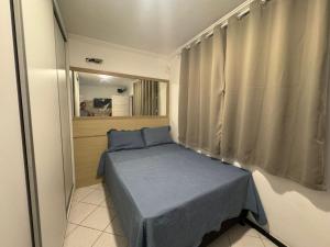 a small bedroom with a bed and a window at Espaço rosa mar in Aracaju