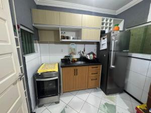 a small kitchen with a refrigerator and a sink at Espaço rosa mar in Aracaju