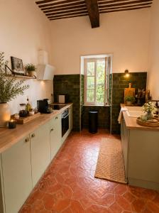 a kitchen with white cabinets and a counter top at Entre Ciels et Lettres in Grignan
