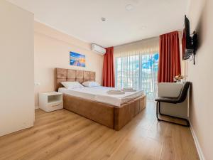 a bedroom with a large bed and a television in it at Pensiunea Riviera in Costinesti