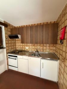 a kitchen with white cabinets and a sink at Capanna Tremorgio in Quinto