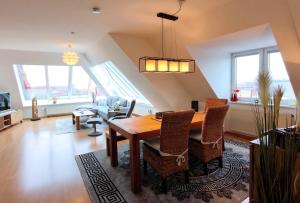 a living room with a wooden table and chairs at Traumblick Barth - Boddenblick, Tiefgarage & Aufzug in Barth