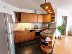 a kitchen with wooden cabinets and a stainless steel refrigerator at Traumblick Barth - Boddenblick, Tiefgarage & Aufzug in Barth