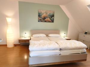 a bedroom with two beds and a painting on the wall at Traumblick Barth - Boddenblick, Tiefgarage & Aufzug in Barth