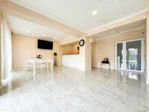a large room with a table and a clock on the wall at Pensiunea Riviera in Costinesti