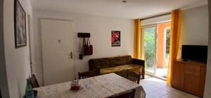 a living room with a table and a couch at Beau séjour in Prayssac