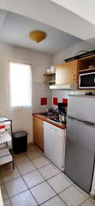 a kitchen with a refrigerator and a counter top at Beau séjour in Prayssac