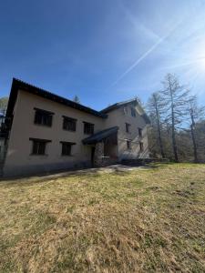 a large white house with a large grass yard at Capanna Tremorgio in Quinto