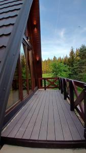a deck of a cabin with a view of the woods at A-Frame Tadić Tara in Ljuboš +14 photos