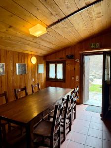 a dining room with a large wooden table and chairs at Capanna Tremorgio in Quinto +74 photos