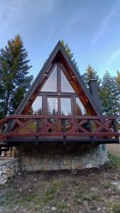 a timber frame house with a large window at A-Frame Tadić Tara in Ljuboš