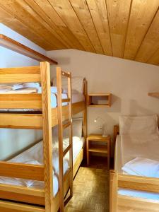 a room with three bunk beds in a cabin at Capanna Tremorgio in Quinto