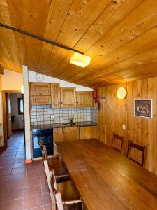 a kitchen with a large wooden table and chairs at Capanna Tremorgio in Quinto