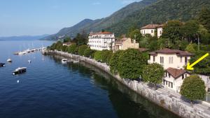 a river with boats in the water next to buildings at Casa Caprice in Cannero Riviera