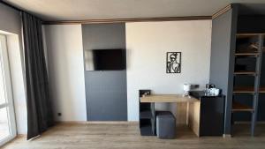 a room with a table and a television on a wall at LESS HOTEL Затока in Zatoka