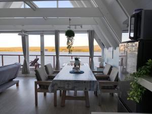 a dining room with a table and chairs with a view of the water at Awesome AFrame in Witsand