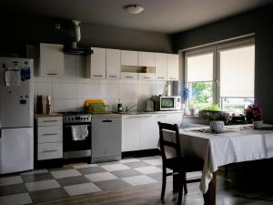 a kitchen with white appliances and a table with a tablecloth at Dom jednorodzinny NOWA in Dęblin