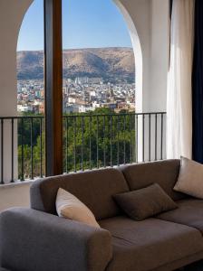 a couch sitting in a room with a large window at View Lounge Hotel in As Sulaymānīyah