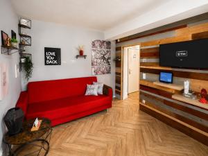 a living room with a red couch and a flat screen tv at Sweet Home in Klagenfurt +51 photos