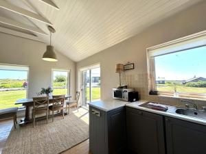 a kitchen with a sink and a table with a microwave at Murlach Moorings in Ballyconneely