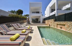 a swimming pool with chaise lounge chairs and a house at Kanavayen Tres in Santanyi