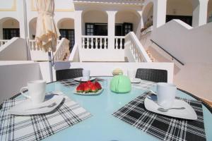 a table with two cups and a bowl of fruit on it at Charming Vila Van Gogh in Luz