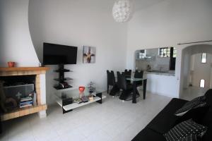 a living room with a fireplace and a table with chairs at Charming Vila Van Gogh in Luz