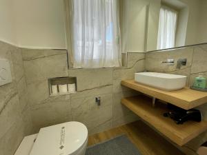 a bathroom with a white toilet and a sink at Casa Caprice in Cannero Riviera