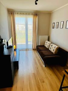 a living room with a couch and a large window at Zaczarowana Rotmanka in Rotmanka