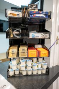 a shelf with cups of food on a counter at Saram Lodge Lichfield in Lichfield