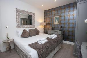 a bedroom with a bed with a mirror on the wall at Cameron North Lodge in Balloch