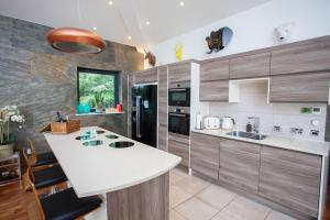 a kitchen with a white counter and wooden cabinets at Cameron North Lodge in Balloch