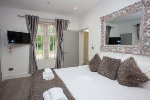 a bedroom with a large white bed with a mirror at Cameron North Lodge in Balloch +43 photos