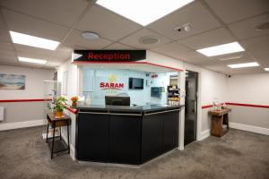 an office with a reception counter with a saami sign at Saram Lodge Lichfield in Lichfield
