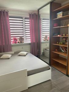 a bedroom with a bed and a window with stuffed animals at Slnečný byt pri lesoparku in Prievidza