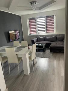 a living room with a table and a couch at Slnečný byt pri lesoparku in Prievidza