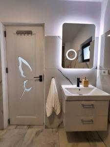 a bathroom with a sink and a door with a mirror at Skylark Apartments in Râmnicu Vâlcea +17 photos