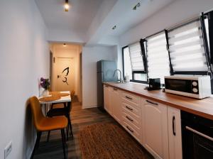 a kitchen with a counter with a microwave and a table at Skylark Apartments in Râmnicu Vâlcea