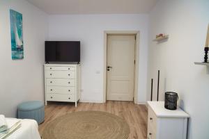 a living room with a tv and a dresser with a television at Skylark Apartments in Râmnicu Vâlcea
