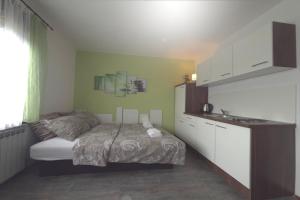 a small bedroom with a bed and a kitchen at ASGARD Guesthouse in Josipdol