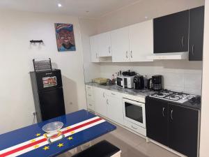 a kitchen with white cabinets and a black refrigerator at Bellamy in Porto Novo