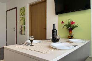 a table with a bottle of wine and two glasses at ASGARD Guesthouse in Josipdol