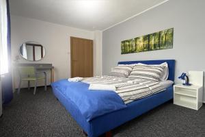 a bedroom with a blue bed and a mirror at ASGARD Guesthouse in Josipdol
