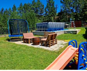 a park with a playground with a slide and chairs at Vikendica i apartman HS in Pirot