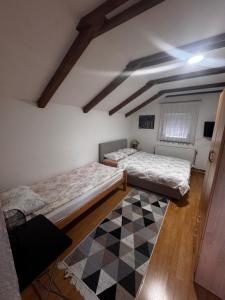 two beds in a room with a checkered floor at Apartments Aida in Bihać