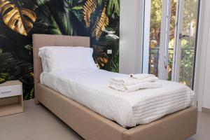 a bed with towels on it in a bedroom at Beach House - Affittacamere Paola in Paola