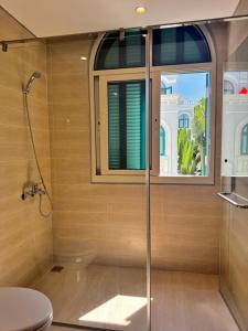 a bathroom with a shower and a toilet and a window at AnHuy Villa in Phú Quốc +22 photos