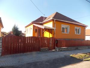 エゲルサロークにあるSzonja Apartmanの木塀のある黄色い家