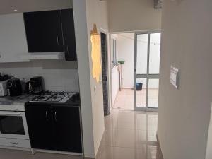 a kitchen with a stove top oven next to a hallway at Bellamy in Porto Novo +8 photos
